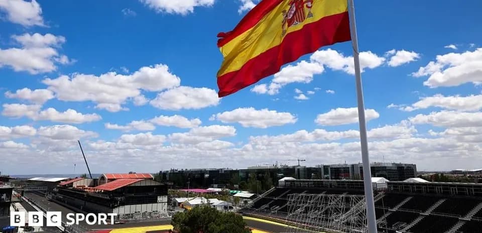 Spanish flag waving over empty racetrack under blue sky