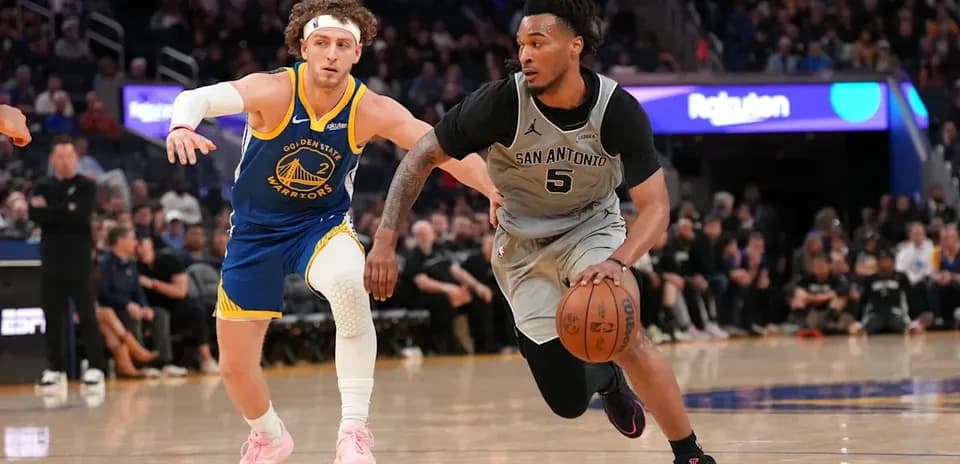 San Antonio player dribbling while pursued by Golden State defender