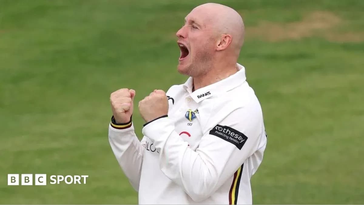Cricketer celebrating with clenched fists on field
