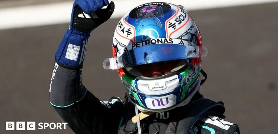 Driver celebrating with raised fist in racing gear