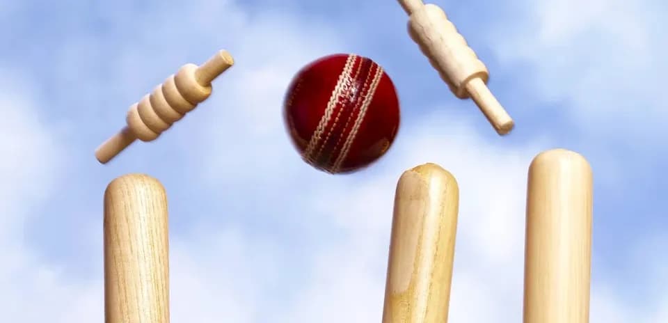 Cricket ball hitting wooden stumps and bails