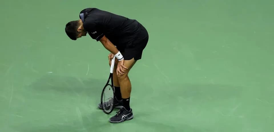Tennis player bending forward on court during match