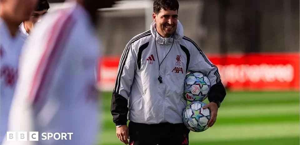 Coach holding footballs during training session