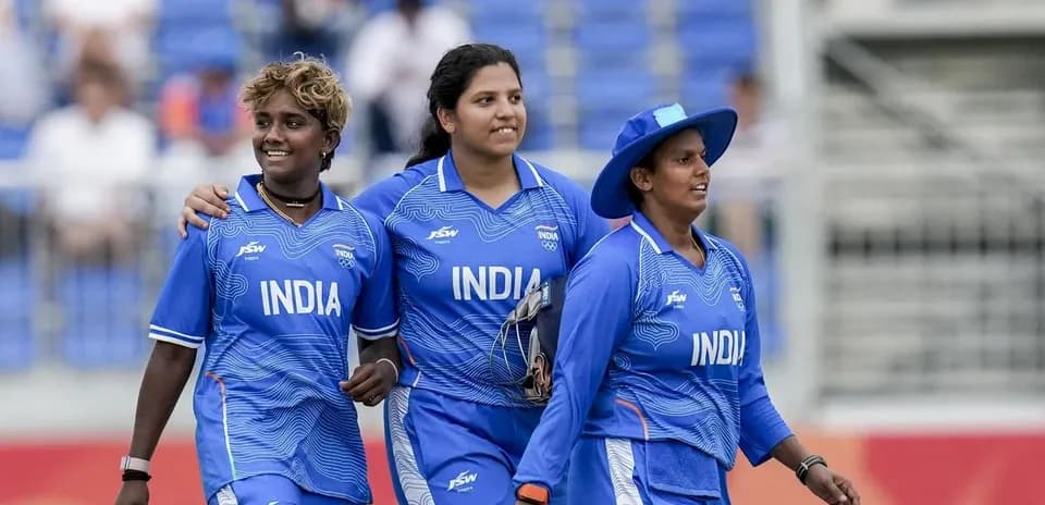 Three Indian cricketers walking together on field