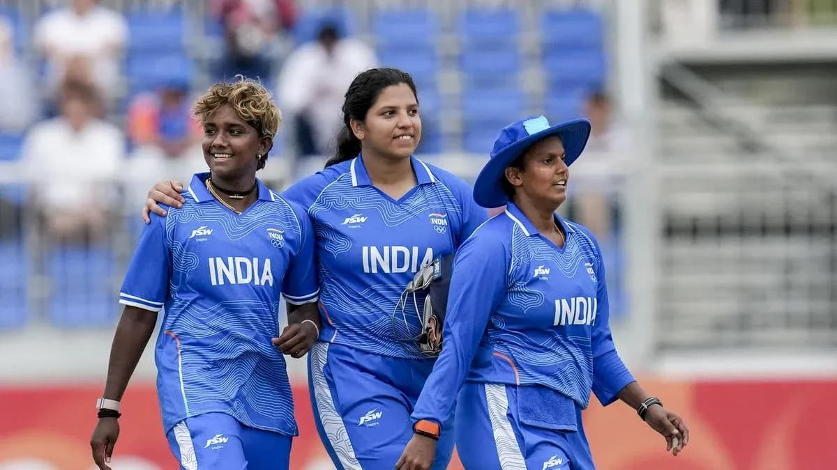 Three Indian cricketers walking together on field