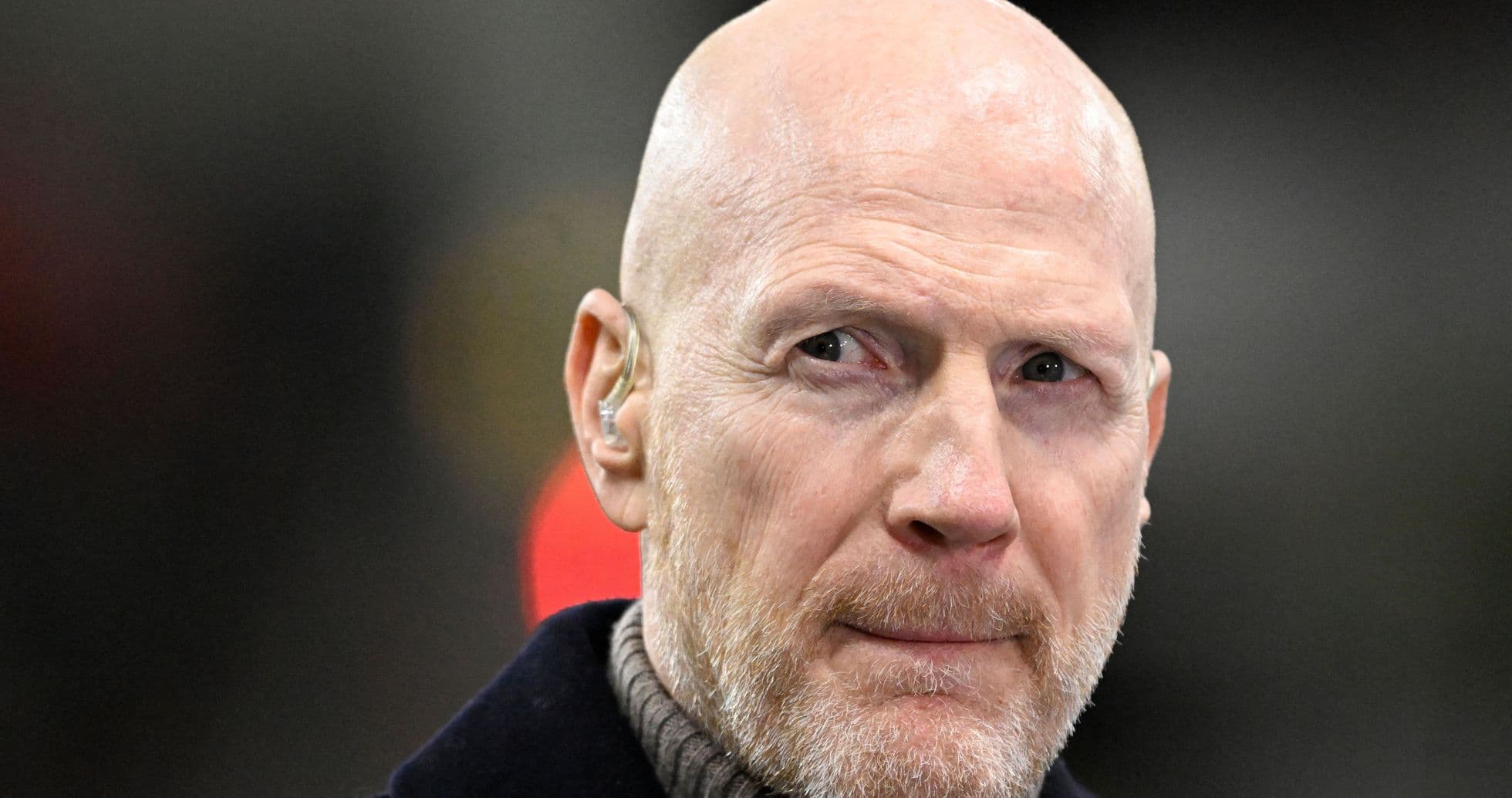 Bald man with a beard wearing an earpiece
