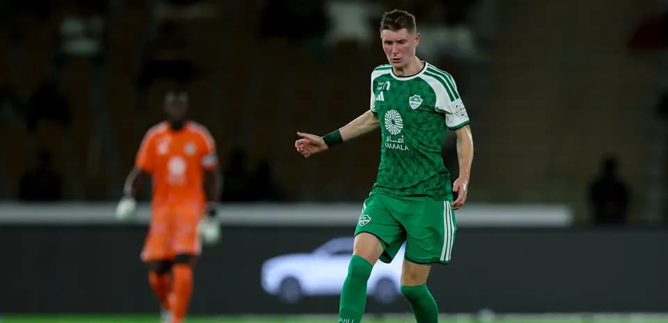 Player in green uniform controlling the ball on field