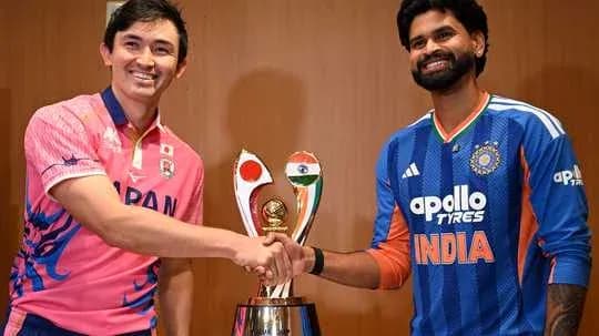 Players shaking hands beside the trophy at event