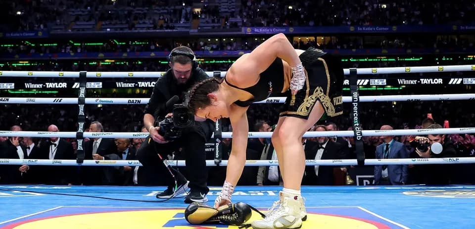 Boxer picking up gloves after winning match