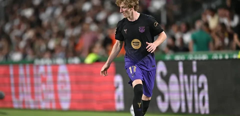 Player in black and purple kit dribbling the ball