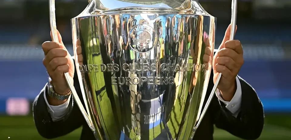 UEFA Champions League trophy held by a person