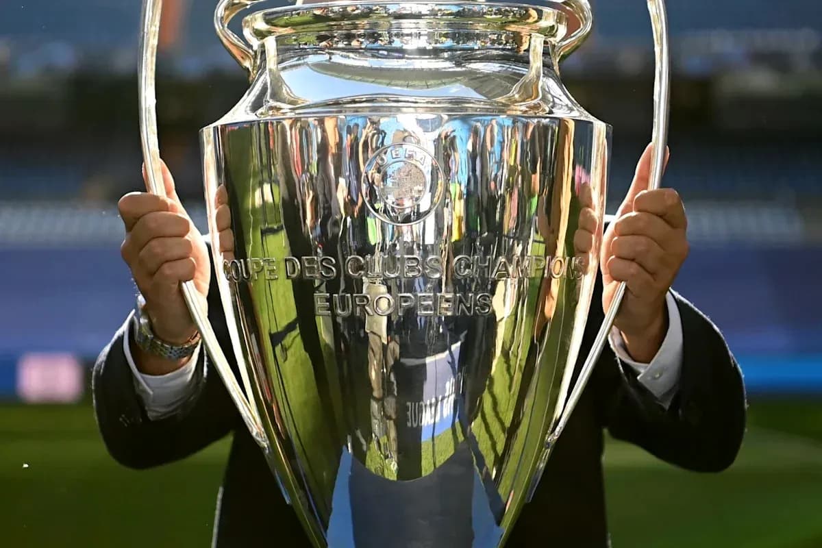 UEFA Champions League trophy held by a person
