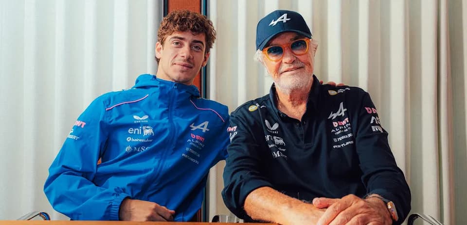 Two men posing together, wearing Alpine team apparel