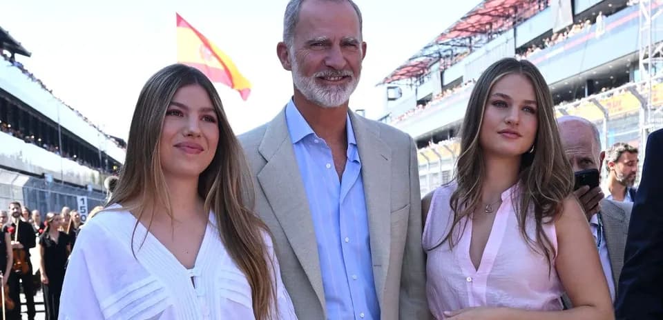 Three people posing at a racing event venue