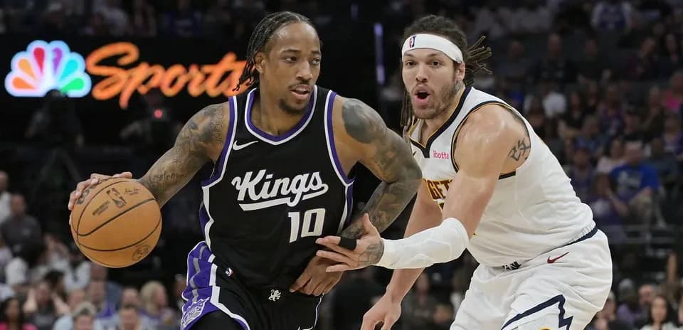 Player dribbling basketball while being defended