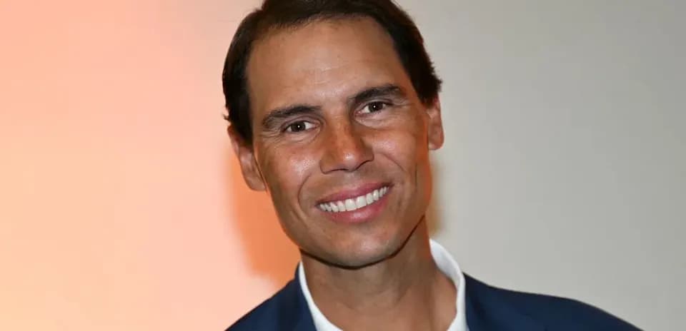 Man smiling in a suit against a neutral background