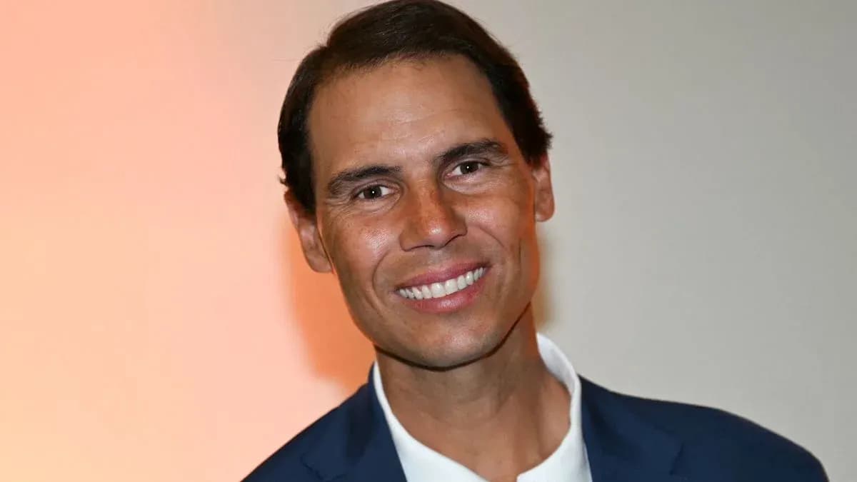 Man smiling in a suit against a neutral background