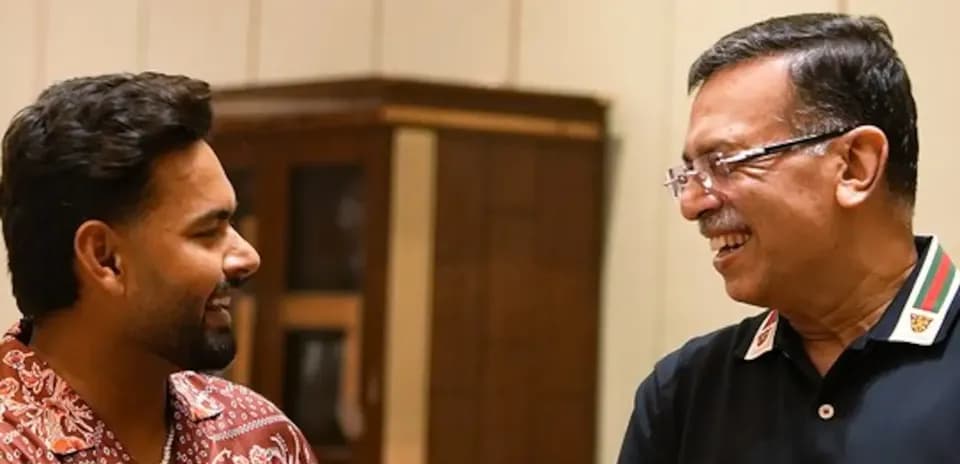 Two men smiling and talking in a room