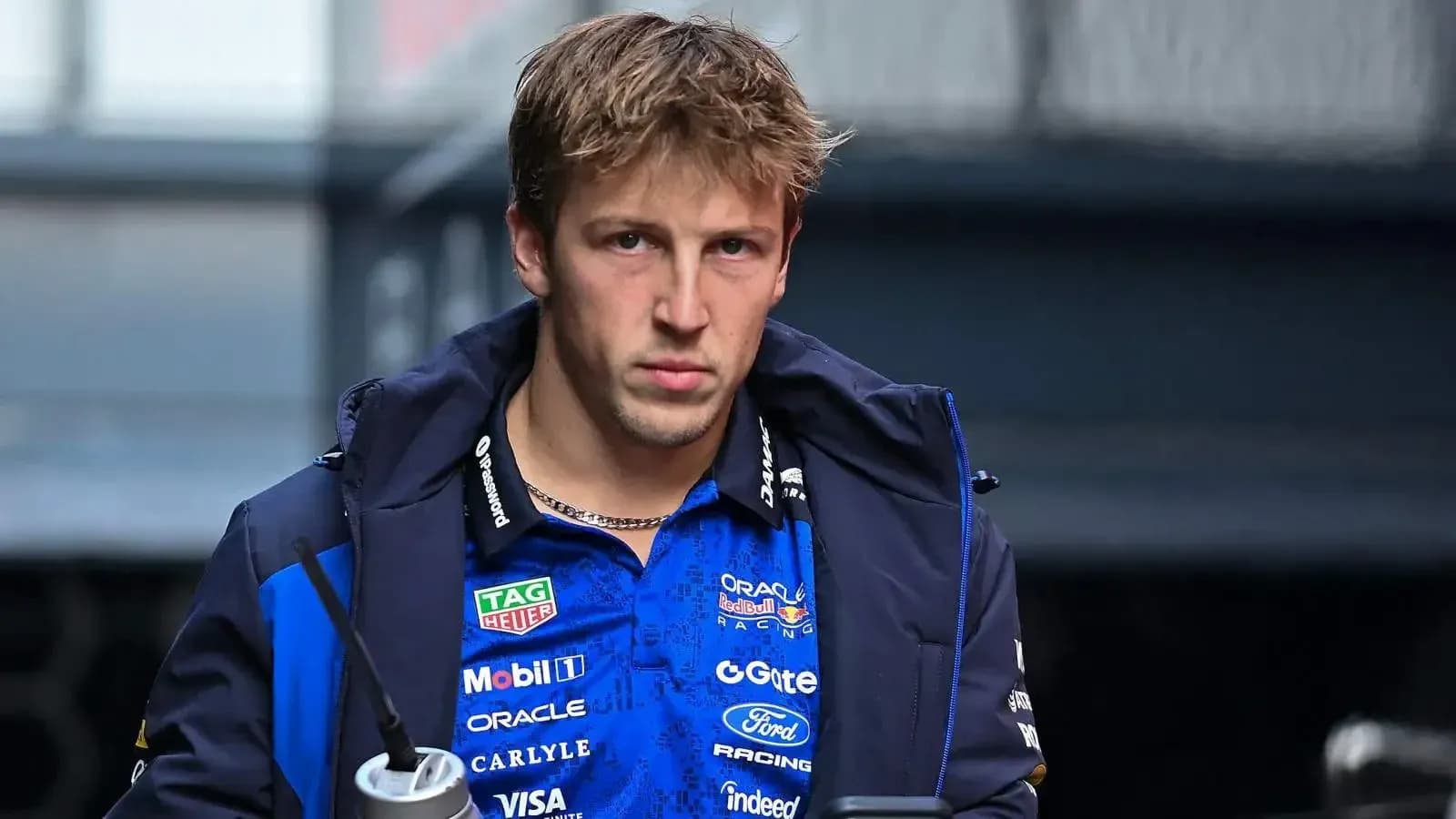 Driver walking in team jacket with drink
