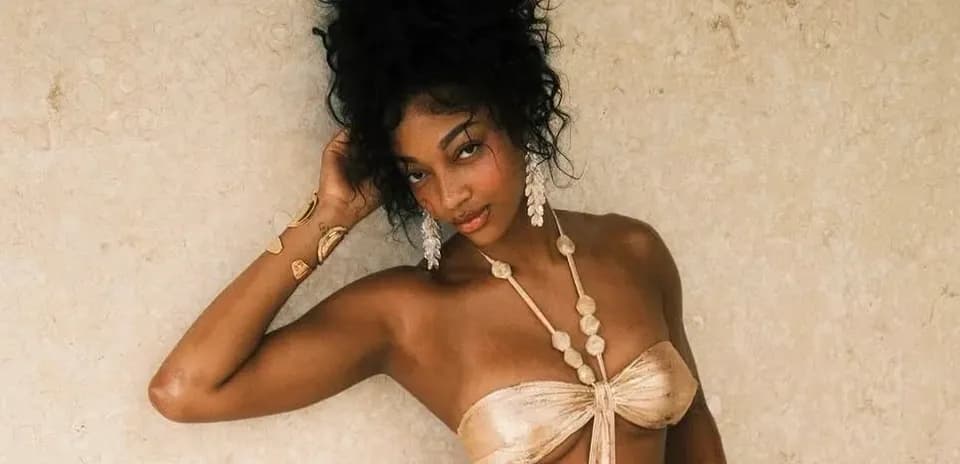 Model posing against a textured wall backdrop