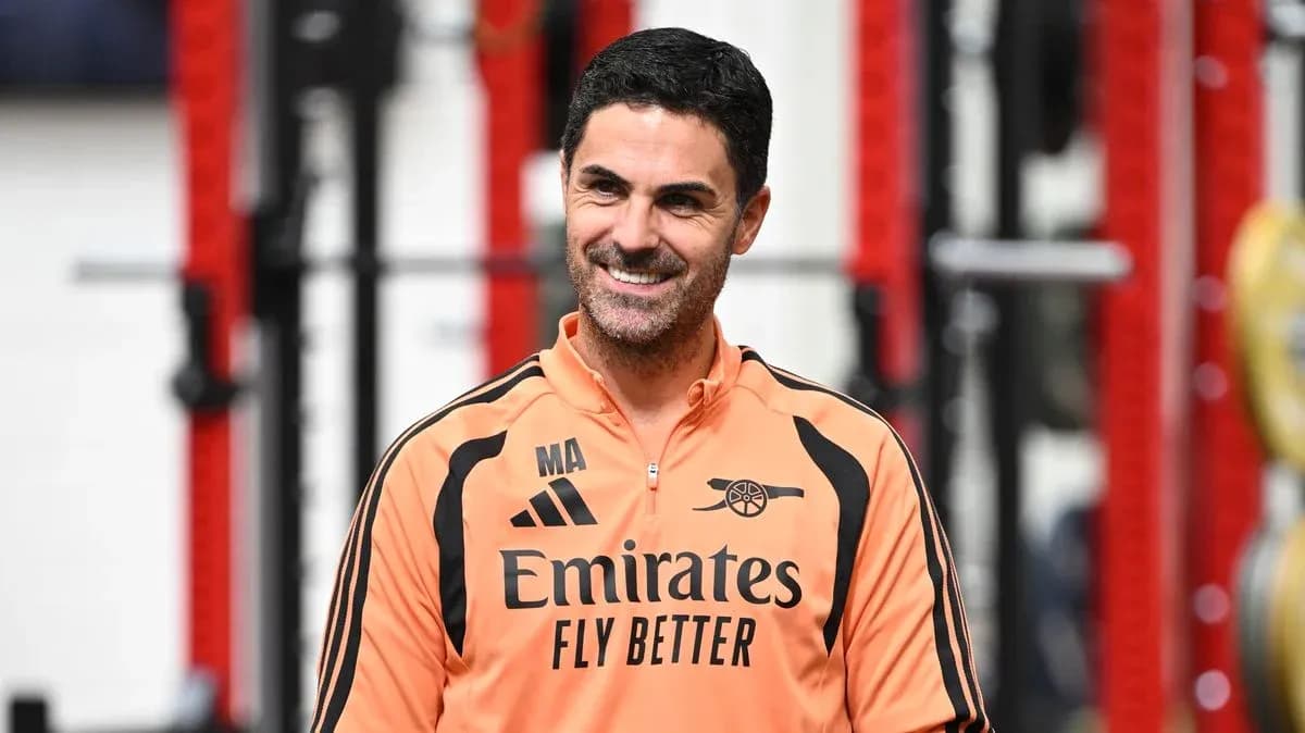 Coach in training gear smiling in gym setting