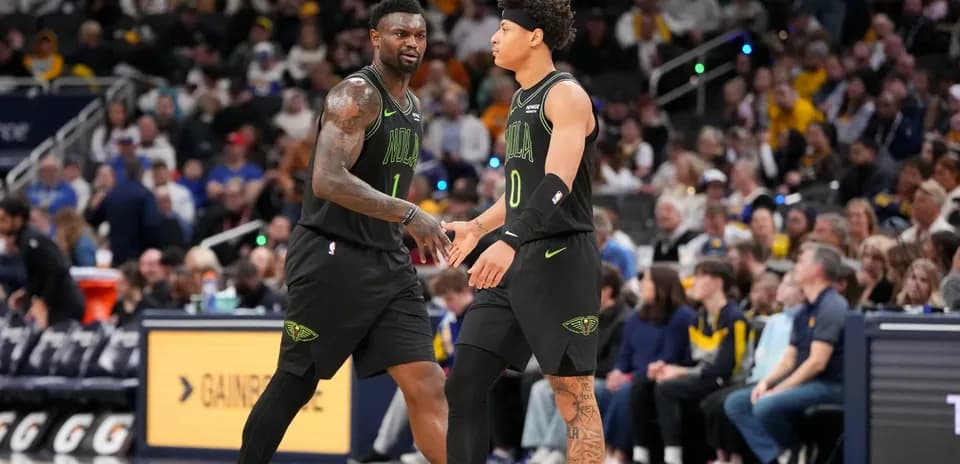 Two players from New Orleans Pelicans high-fiving on court