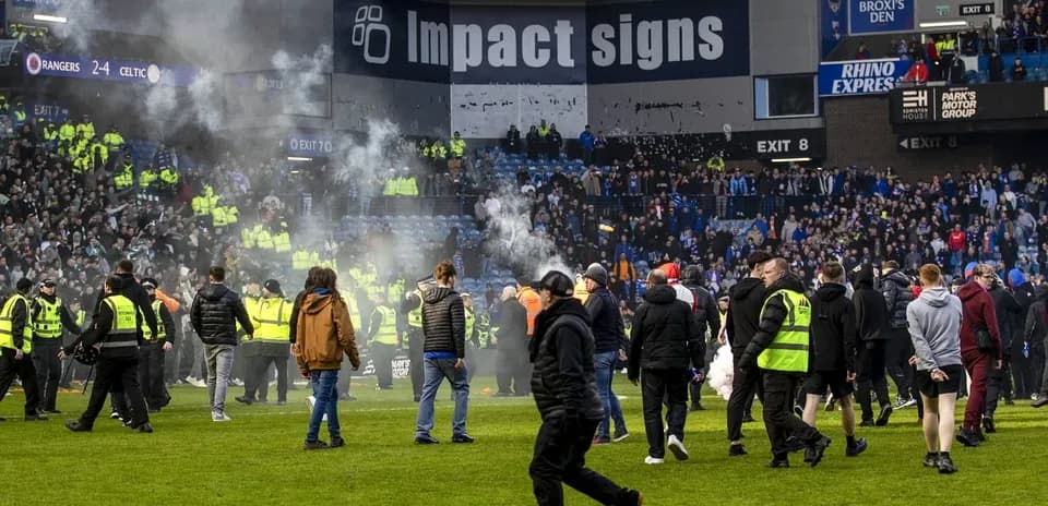 Fans and security on the pitch during disturbance