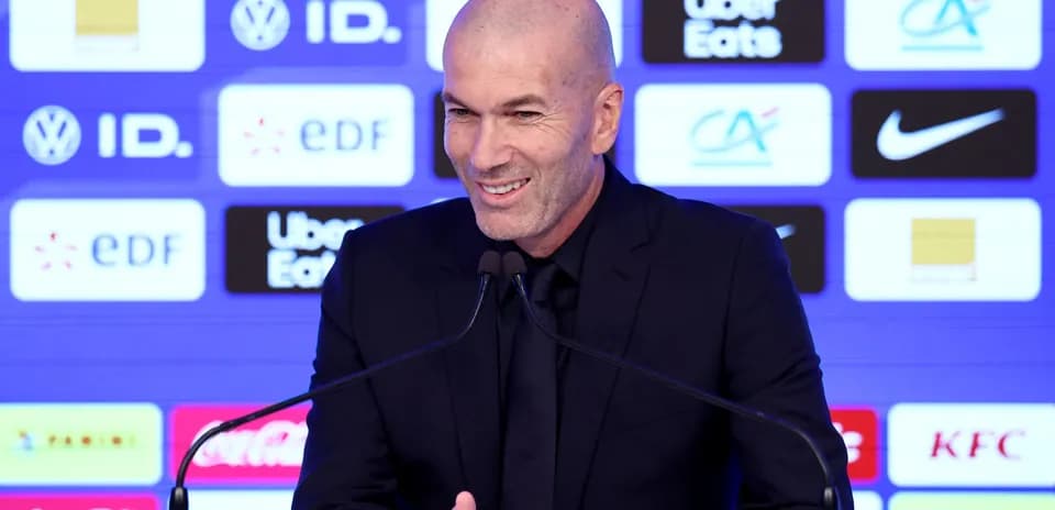 Manager speaking at press conference with sponsors' logos