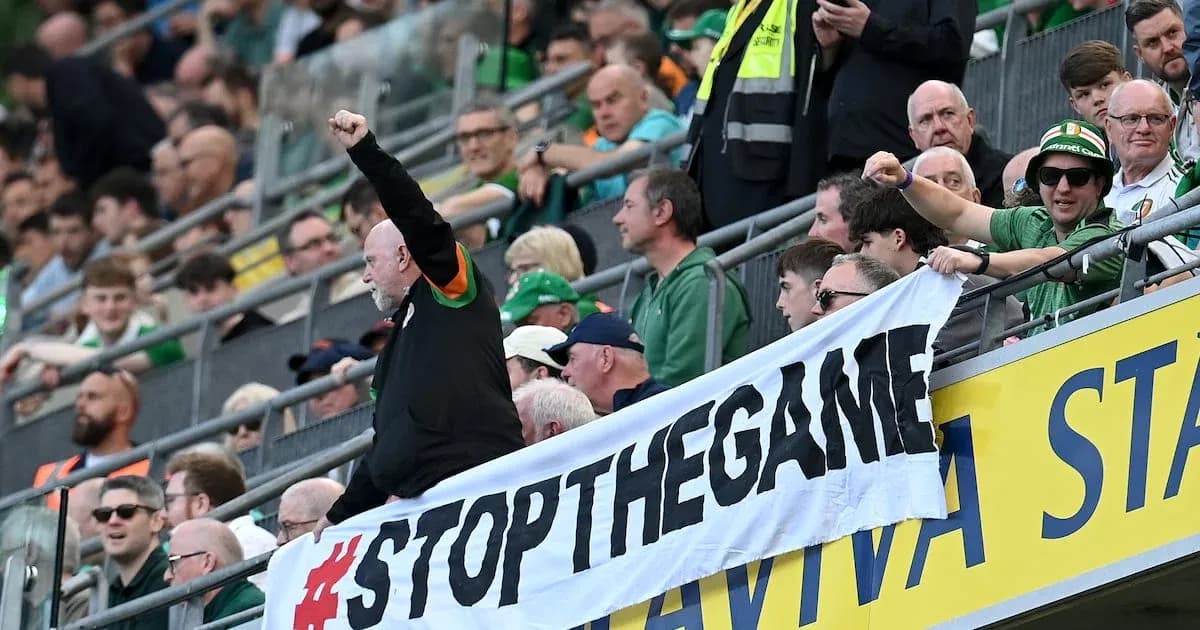 Fans holding a '#STOPTHEGAME' banner in stadium