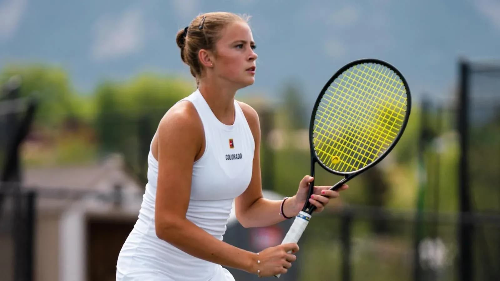 Female tennis player preparing to serve on court