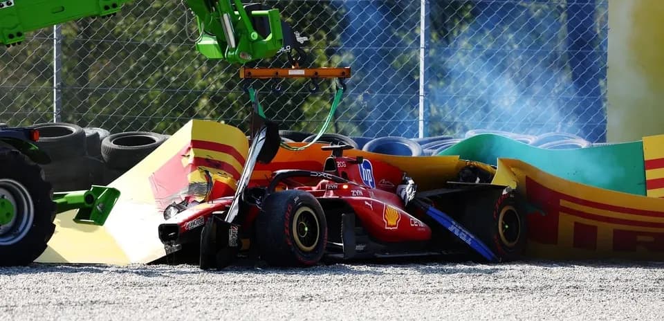 Damaged Ferrari F1 car being lifted from barriers