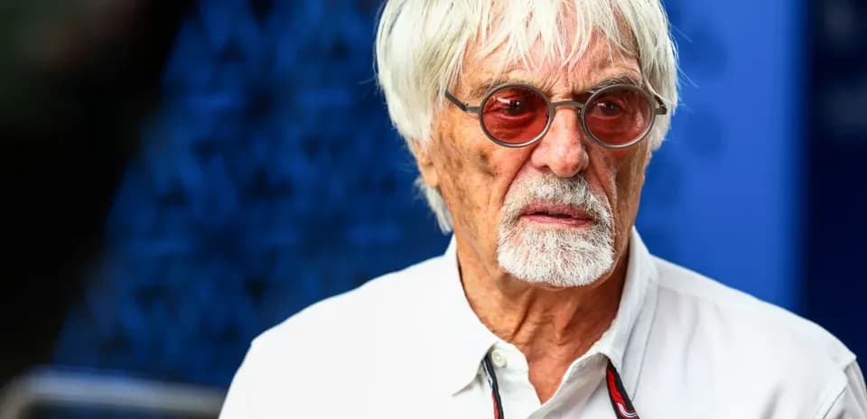 Man with white hair and sunglasses, serious expression