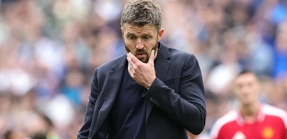 Coach pondering during a football match on the sideline