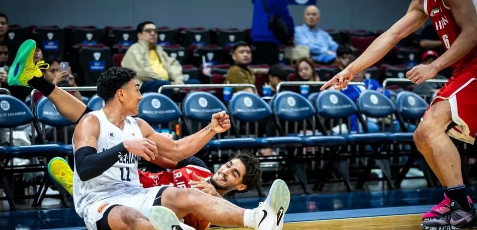 Two basketball players on the court after a fall