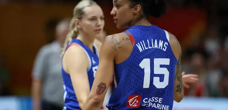 Two basketball players in blue uniforms on court