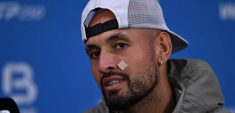 Athlete speaking at press conference with bandage on face