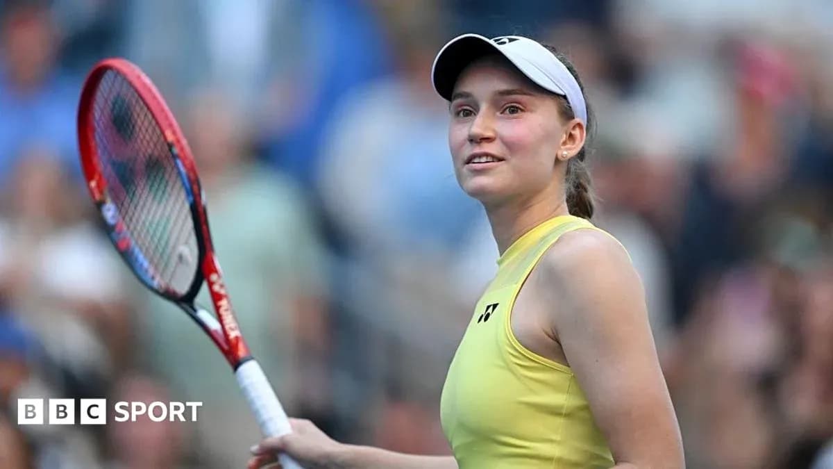 Tennis player holding racket and smiling at crowd