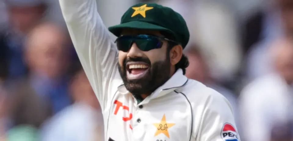 Cricketer celebrating with raised arm on field