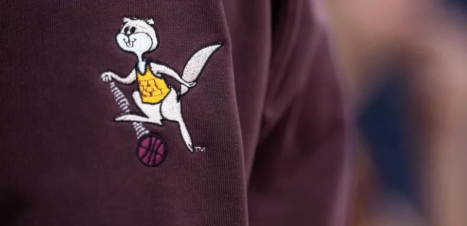 Embroidered mascot logo on maroon clothing