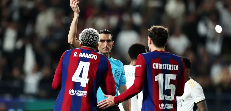 Referee showing yellow card to R. Araujo during match