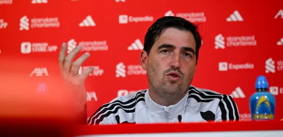 Manager speaking at press conference with team backdrop