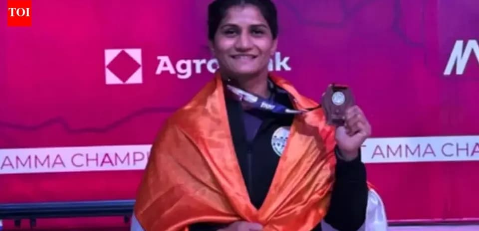 Athlete holding medal, wrapped in Indian flag