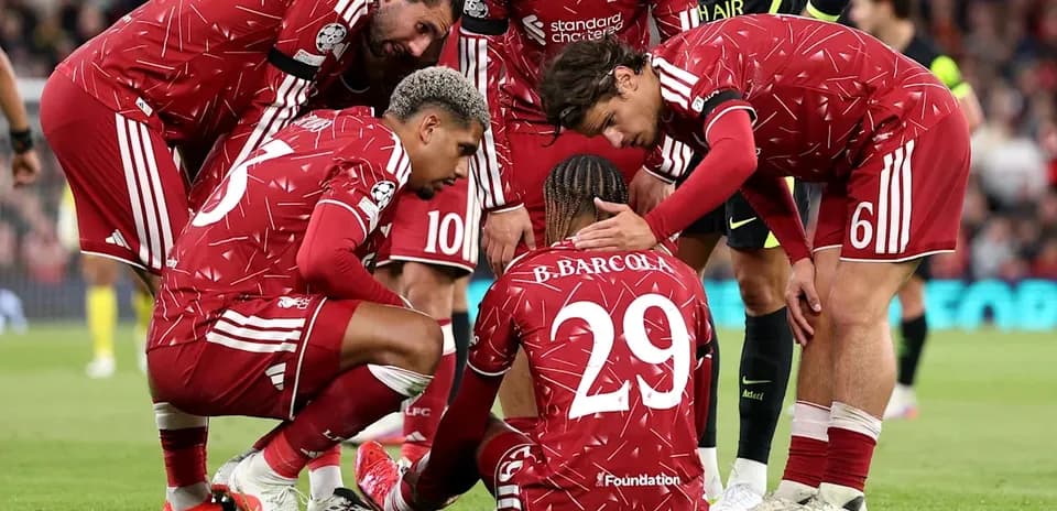 Liverpool players supporting teammate on the field