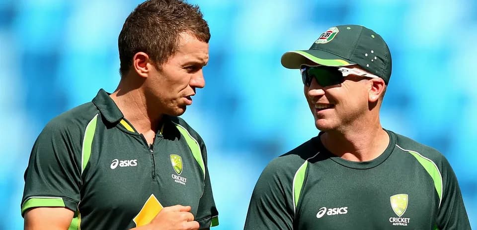 Two Australian cricket players conversing on field