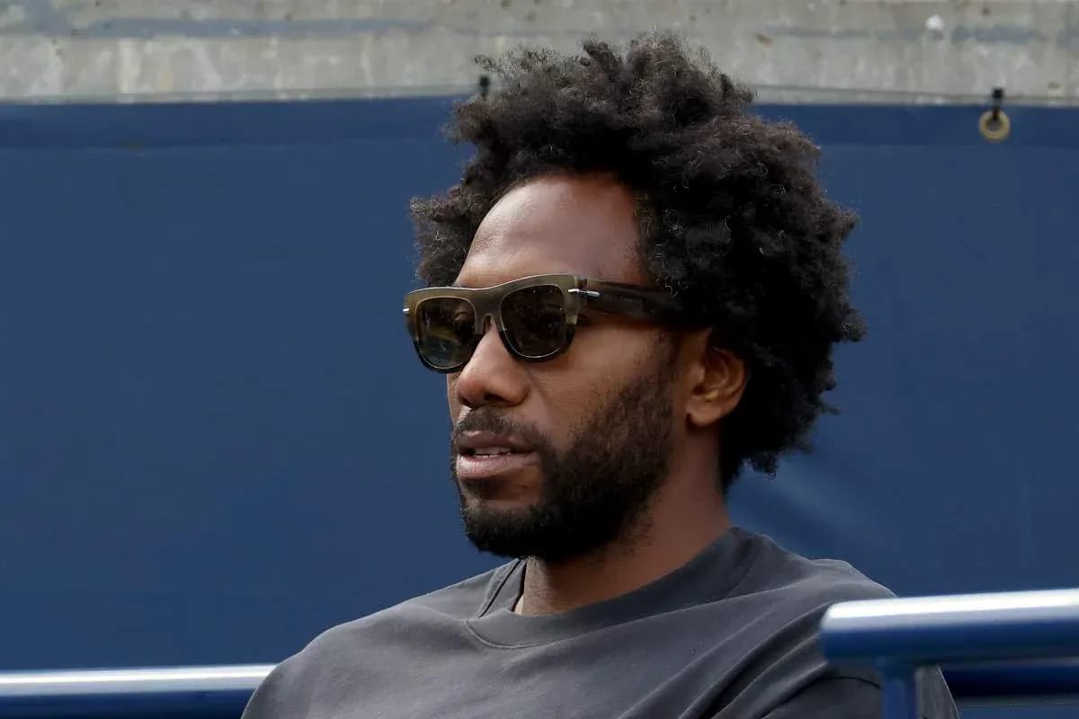 Man with sunglasses sitting on bleachers