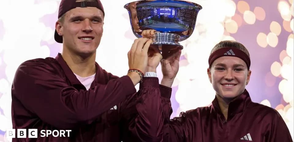 Players celebrating victory holding trophy together