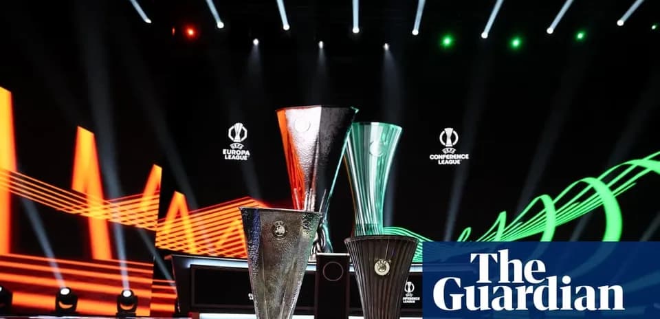 Three UEFA trophies displayed on stage