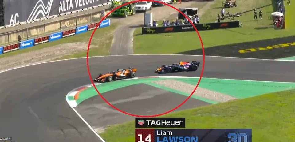 Two Formula 1 cars racing on track at turn