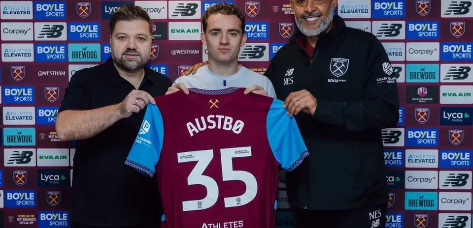 New player holding West Ham jersey at signing event