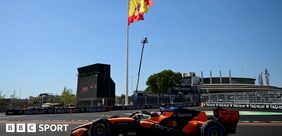 Formula 1 car driving past Spanish flag at circuit